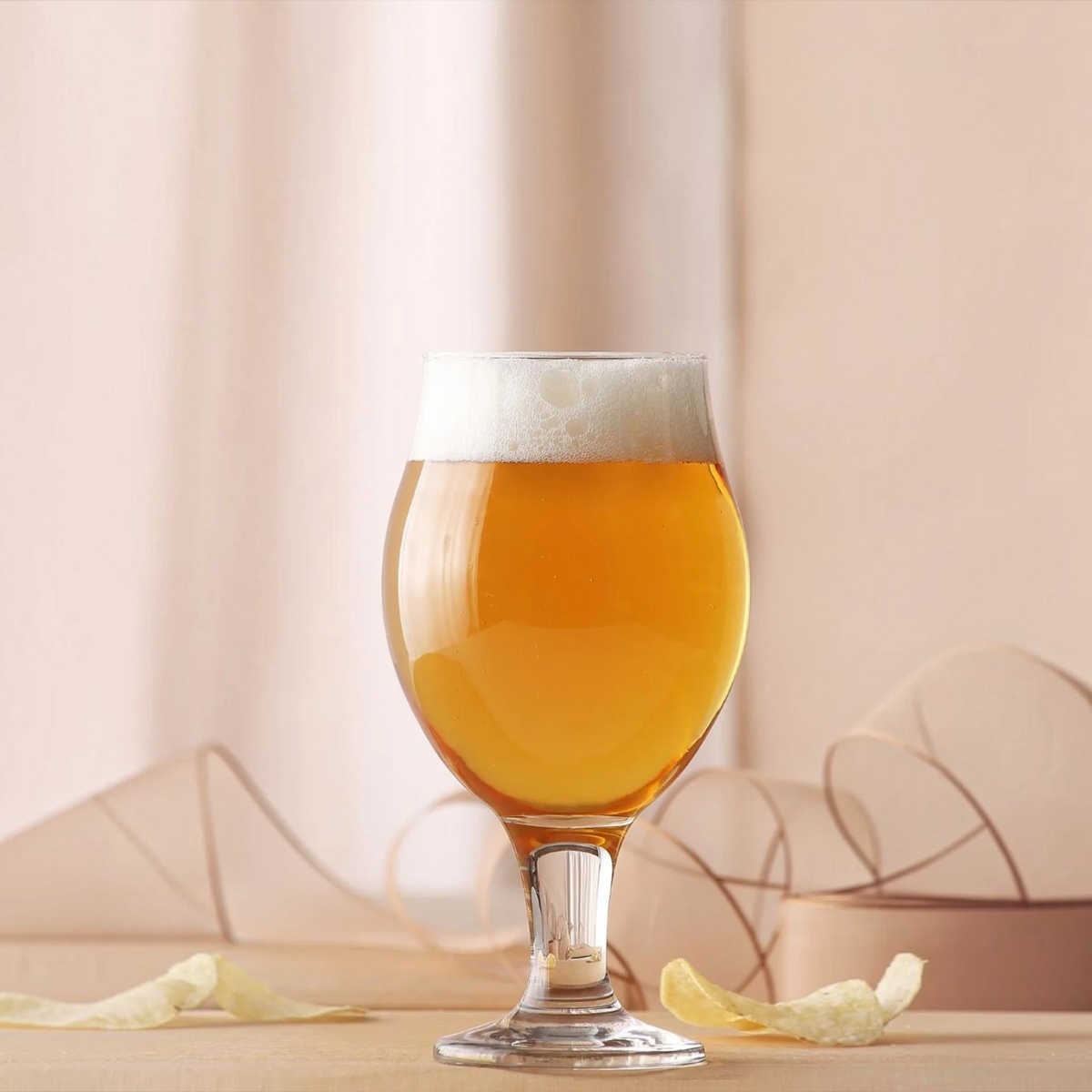 LAV Angelina 19.25 oz footed beer glass filled with beer and foam head, lifestyle shot