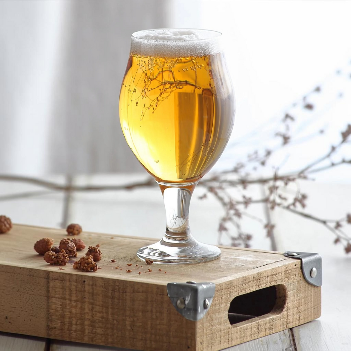 LAV Angelina footed beer glass filled with beer, lifestyle shot on wood crate