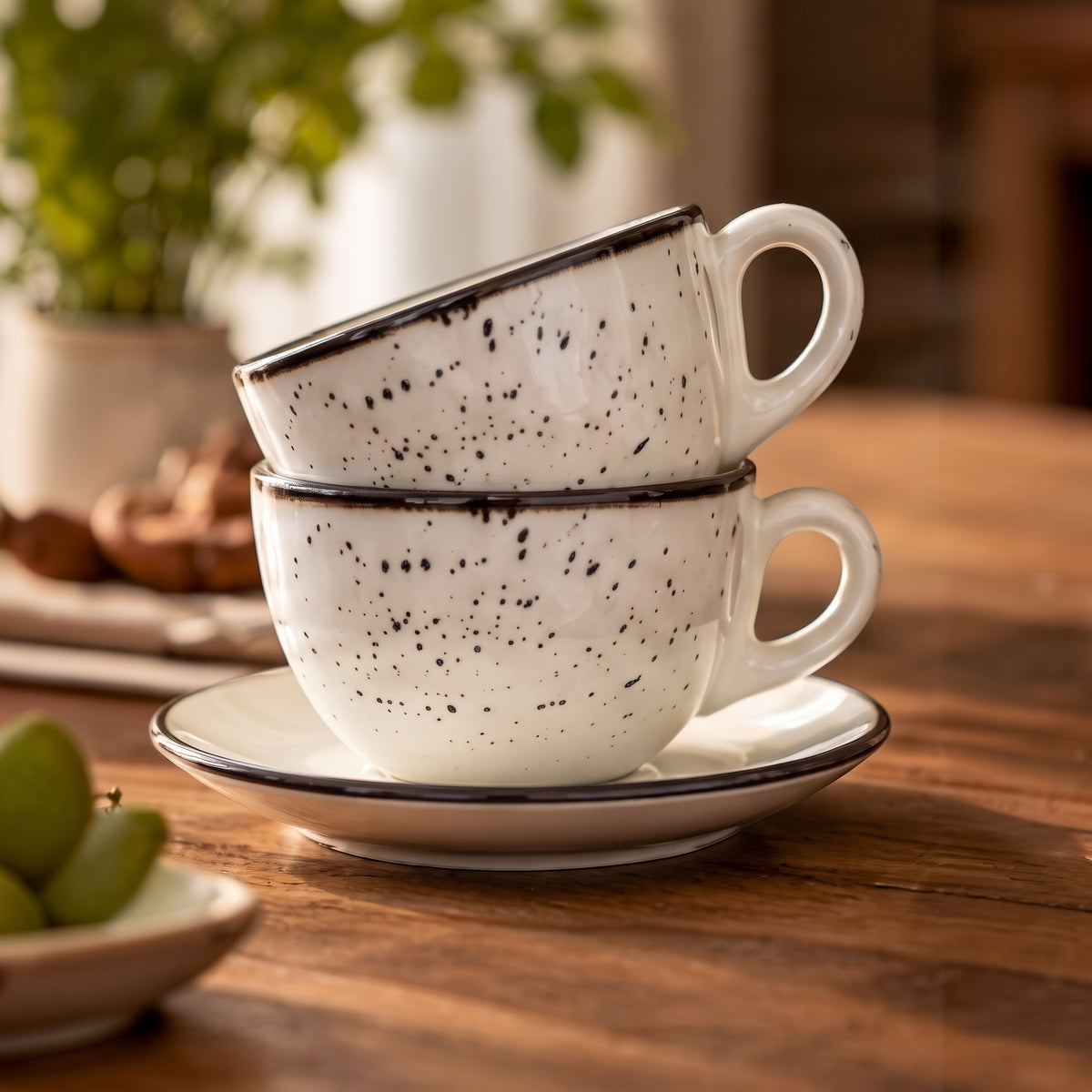 Terra Charcoal stoneware cups stacked on saucer, lifestyle wood table