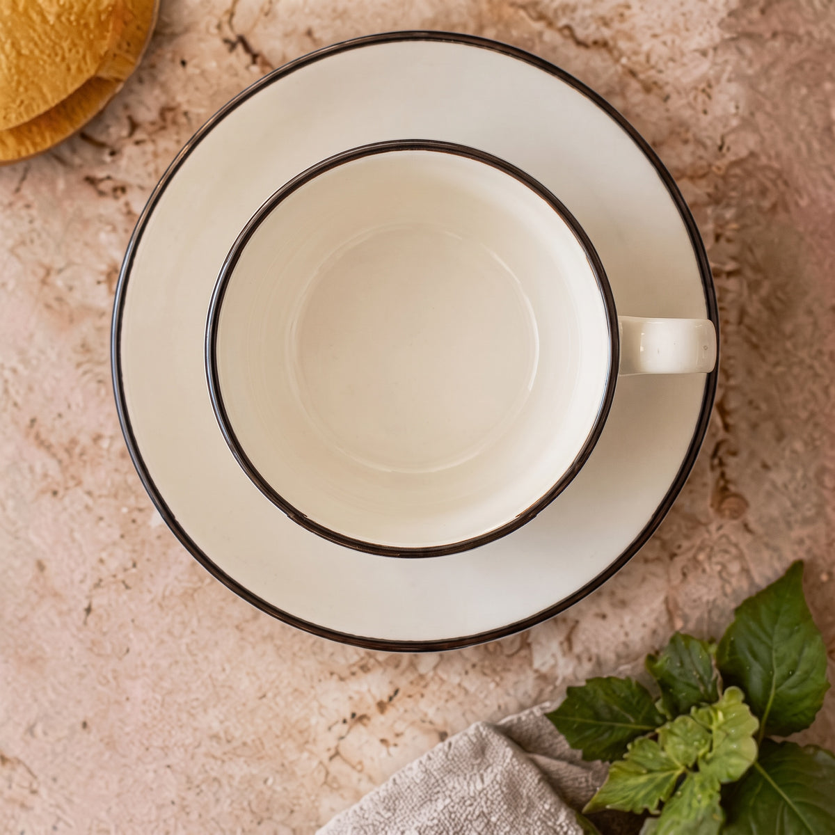 Terra Charcoal stoneware cup and saucer, top-down flat lay view