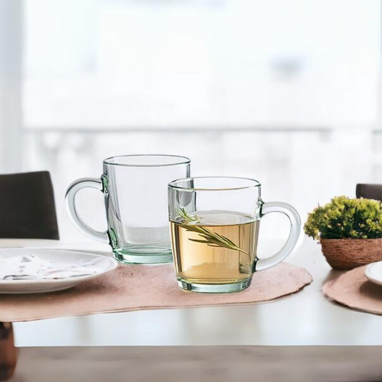 Pasabahce clear glass handled mugs — set of 12, one filled with herbal tea and rosemary on dining table, IKIDO Canada